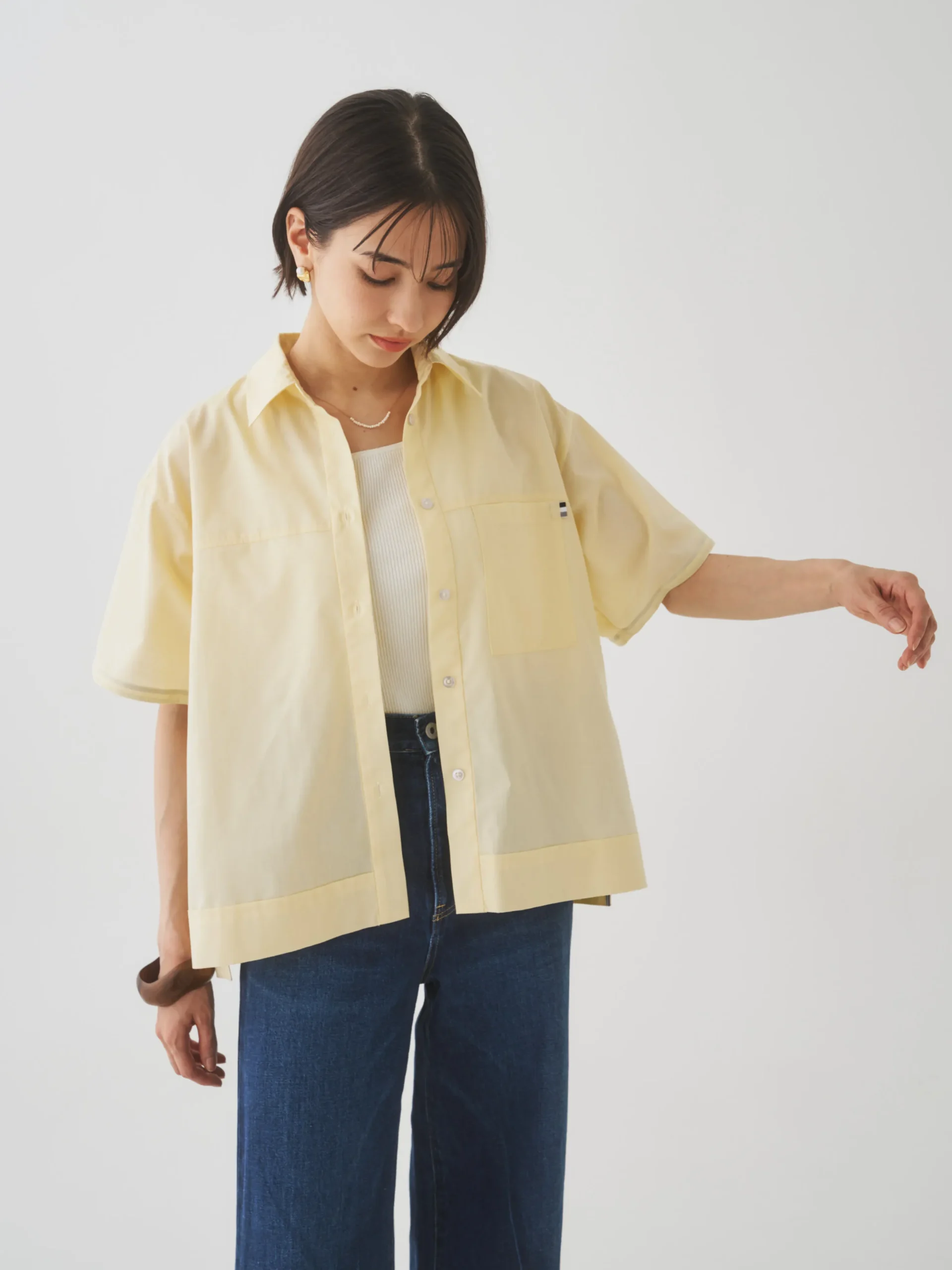 黄色の半袖シャツとデニムを着た女性