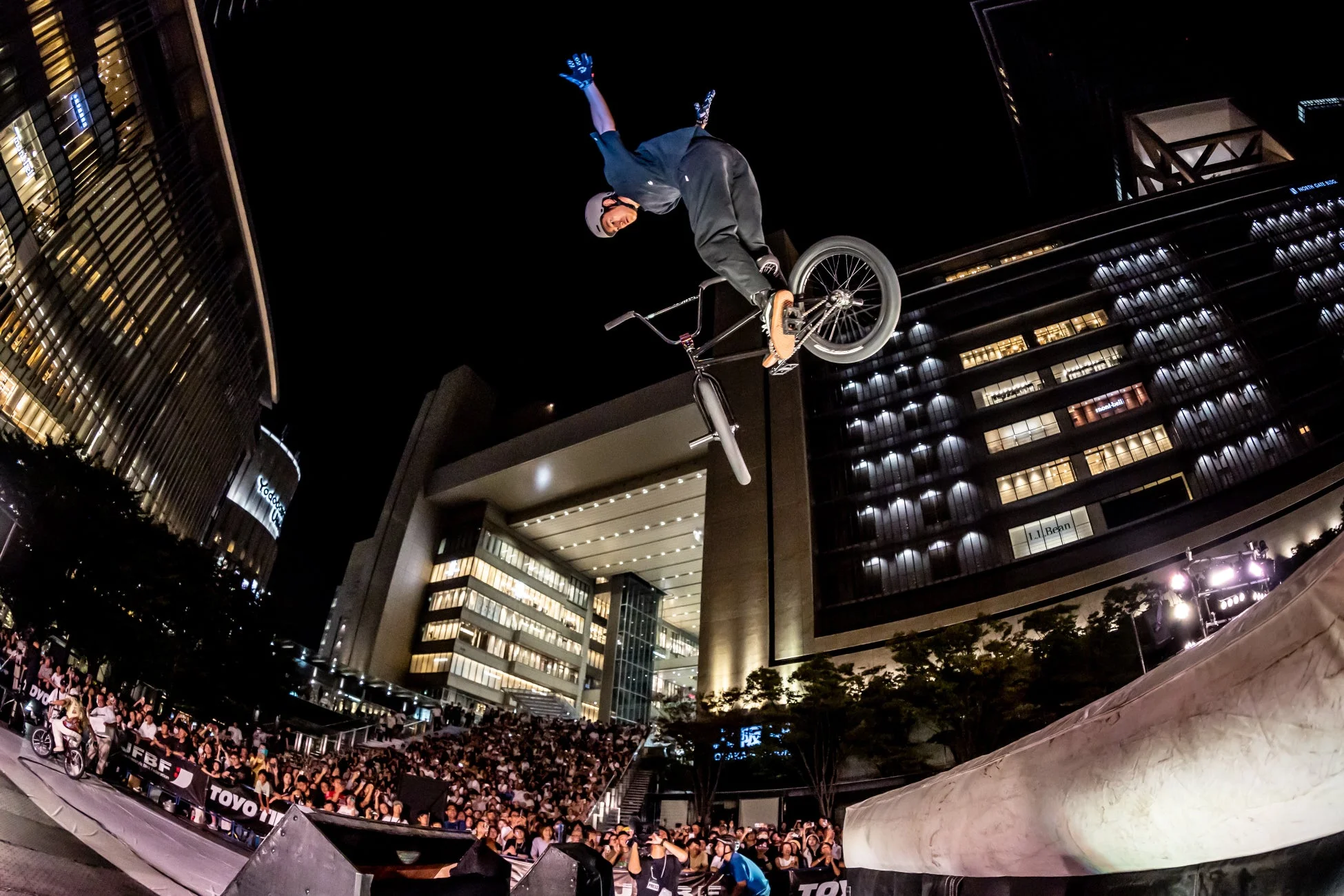 夜の都市を背景にBMXライダーがパフォーマンスする様子