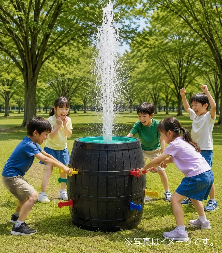 緑豊かな公園で、子供たちが樽型のウォーターゲームで楽しそうに遊んでいます