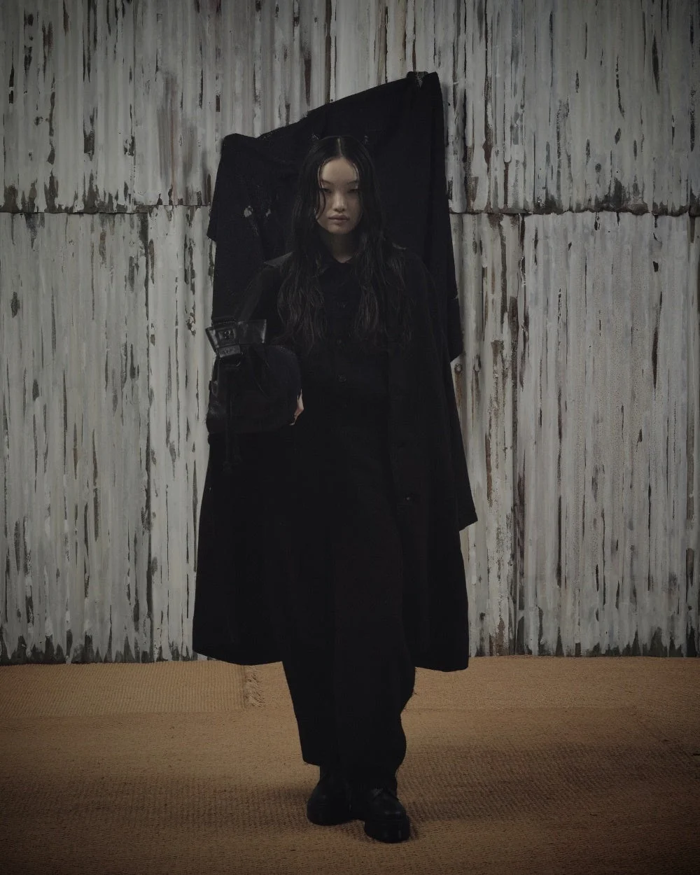 黒いロングコートを着用した女性モデル