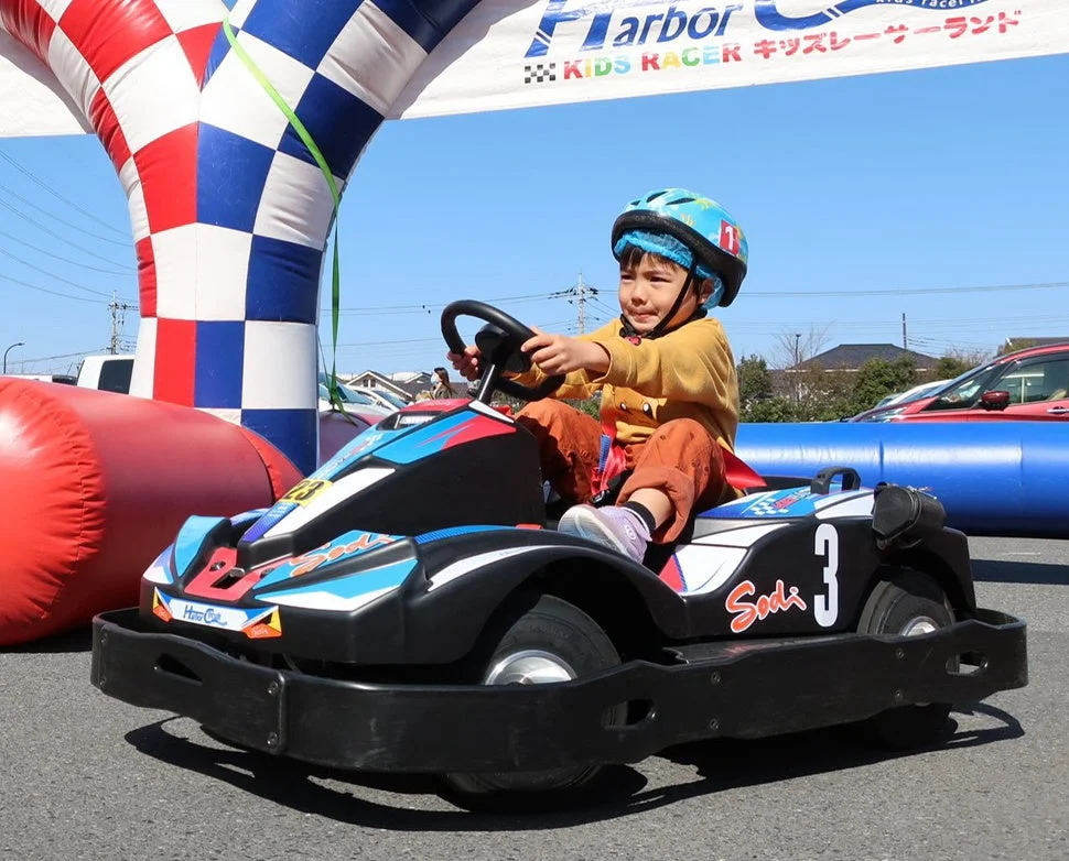 子供がヘルメットを着用してゴーカートに乗っている様子