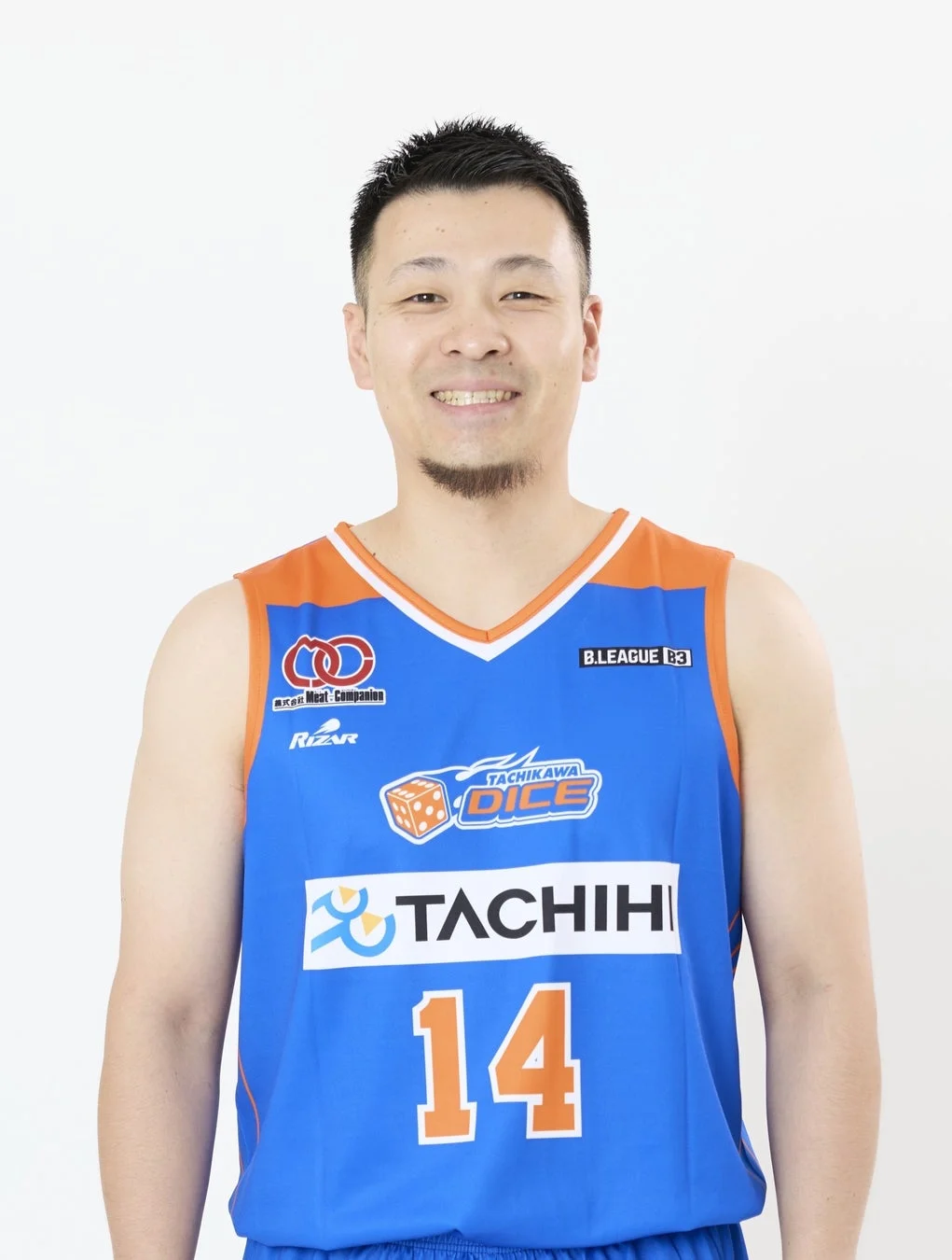 青とオレンジのバスケットボールユニフォームを着た男性が笑顔で写っているポートレート。ユニフォームには背番号14と「TACHIKAWA DICE」、「TACHIHI」などのロゴが見える。