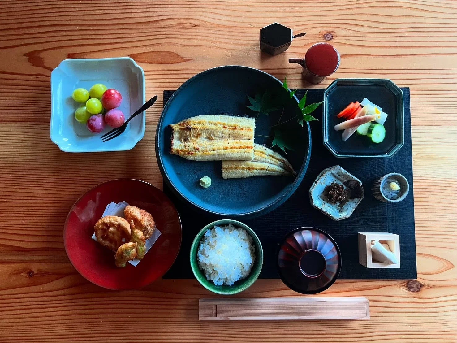 木製のテーブルに並べられた、うなぎをメインとした豪華な和食のお膳