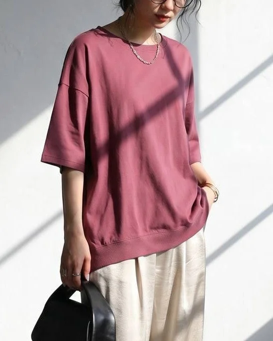 ピンクのオーバーサイズTシャツを着た女性