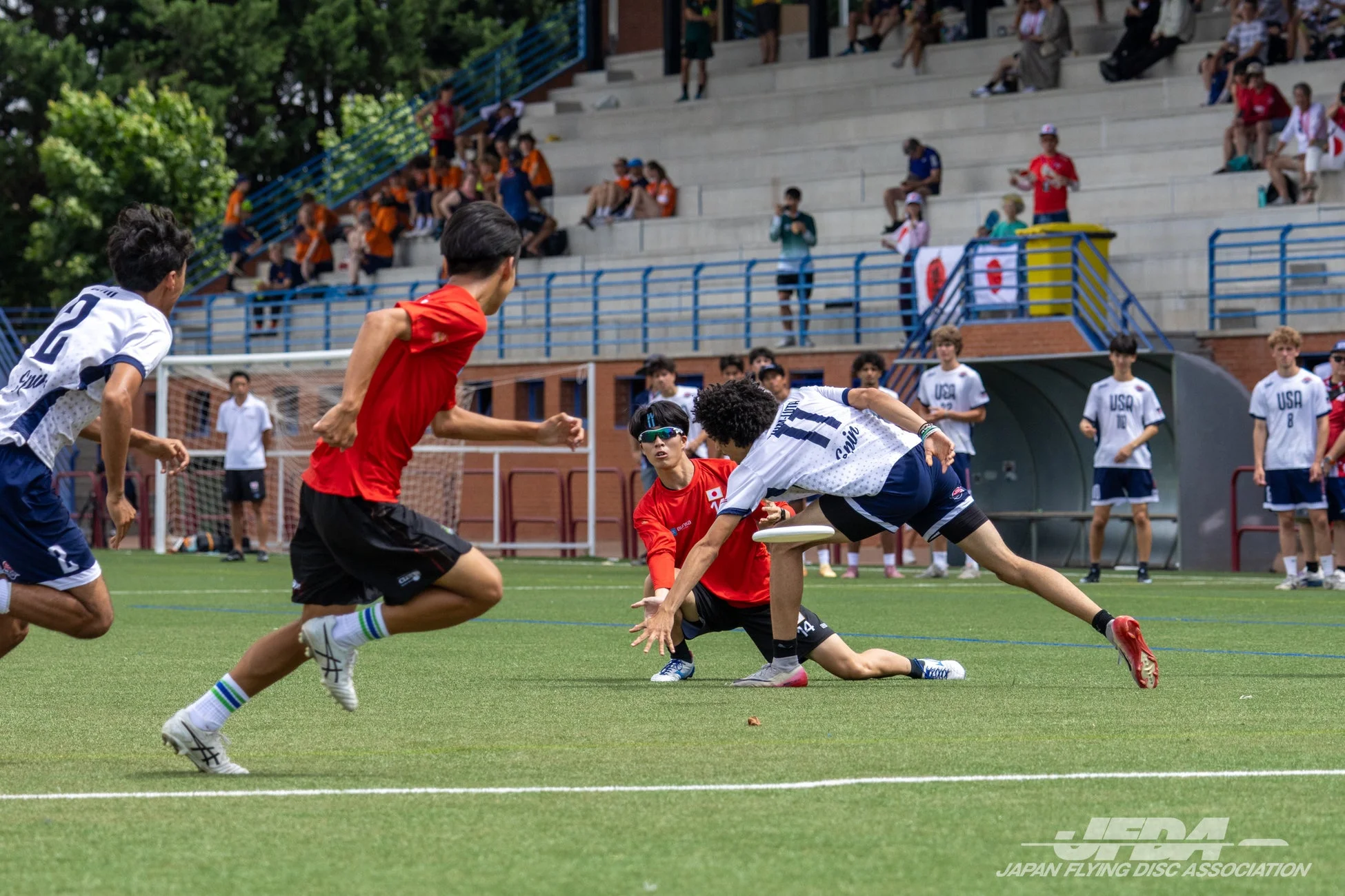 アルティメットの試合中、選手がフライングディスクをキャッチしようとダイブしている瞬間