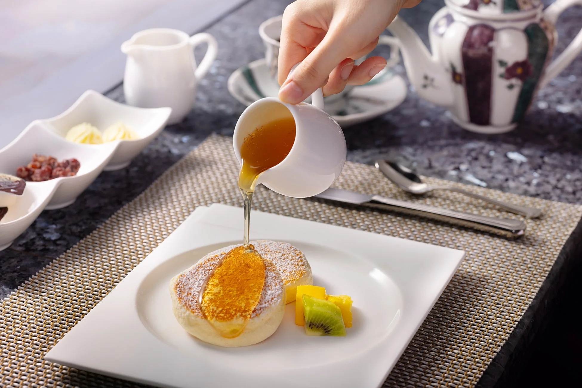 パンケーキにメープルシロップをかける様子