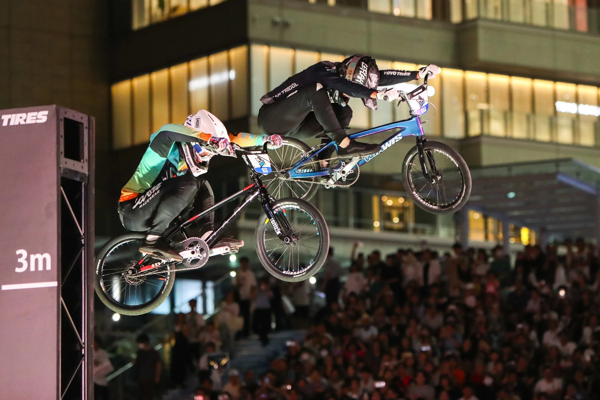 BMXライダーが夜の都会でダイナミックにジャンプする様子