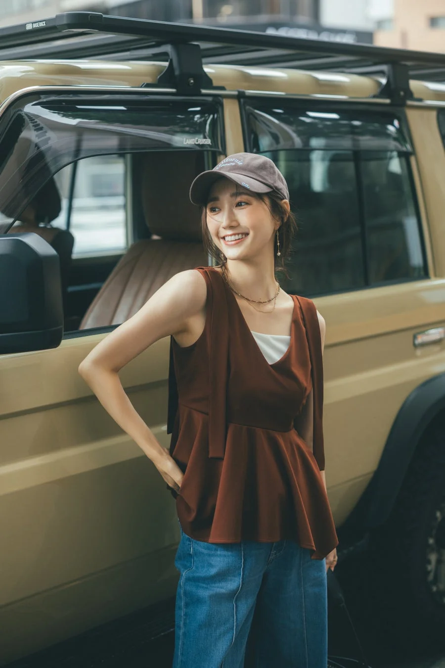SUVの横で笑顔を見せる女性のポートレート
