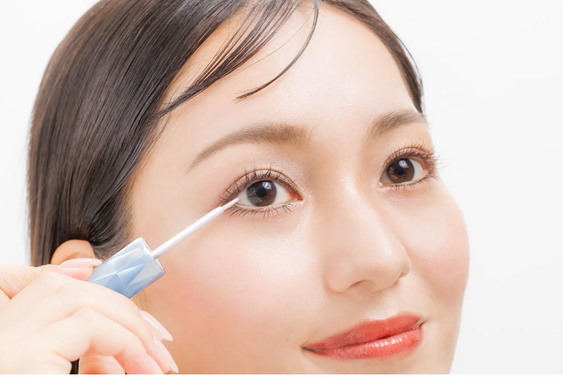 女性が下まつげに美容液を塗っているクローズアップ画像