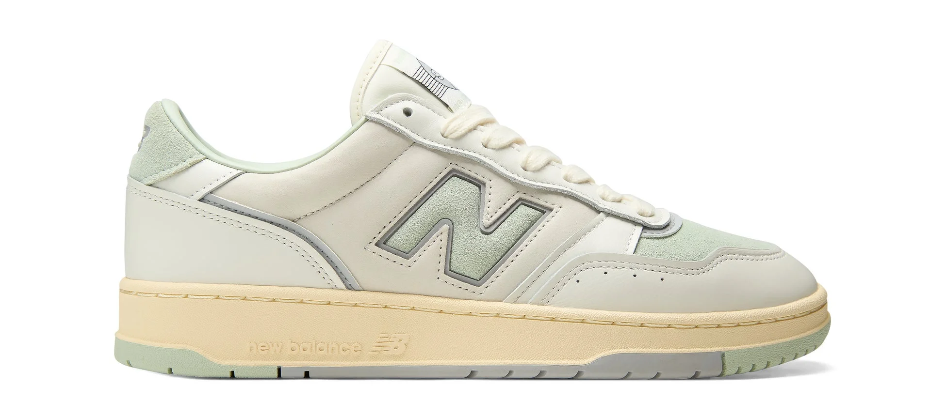 クリーム色とミントグリーンを基調としたNew Balanceのスニーカー
