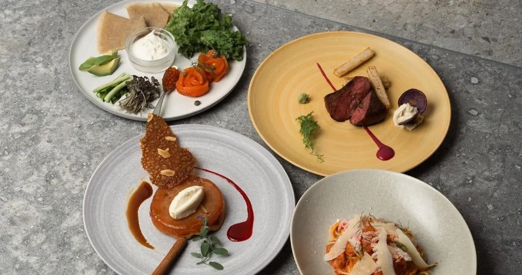 様々な種類の料理が美しく盛り付けられた4皿が並ぶ写真。肉料理、パスタ、前菜、デザートなど、フルコースのような食事が提供されており、高級レストランでの美食体験を思わせます。