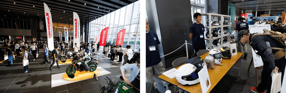 オートバイの展示会で、カワサキ、ホンダ、スズキなどのバイクが多数展示され、多くの来場者で賑わっています。ヘルメットブランドのアライやショウエイのコーナーもあり、人々が熱心に製品を見ています。