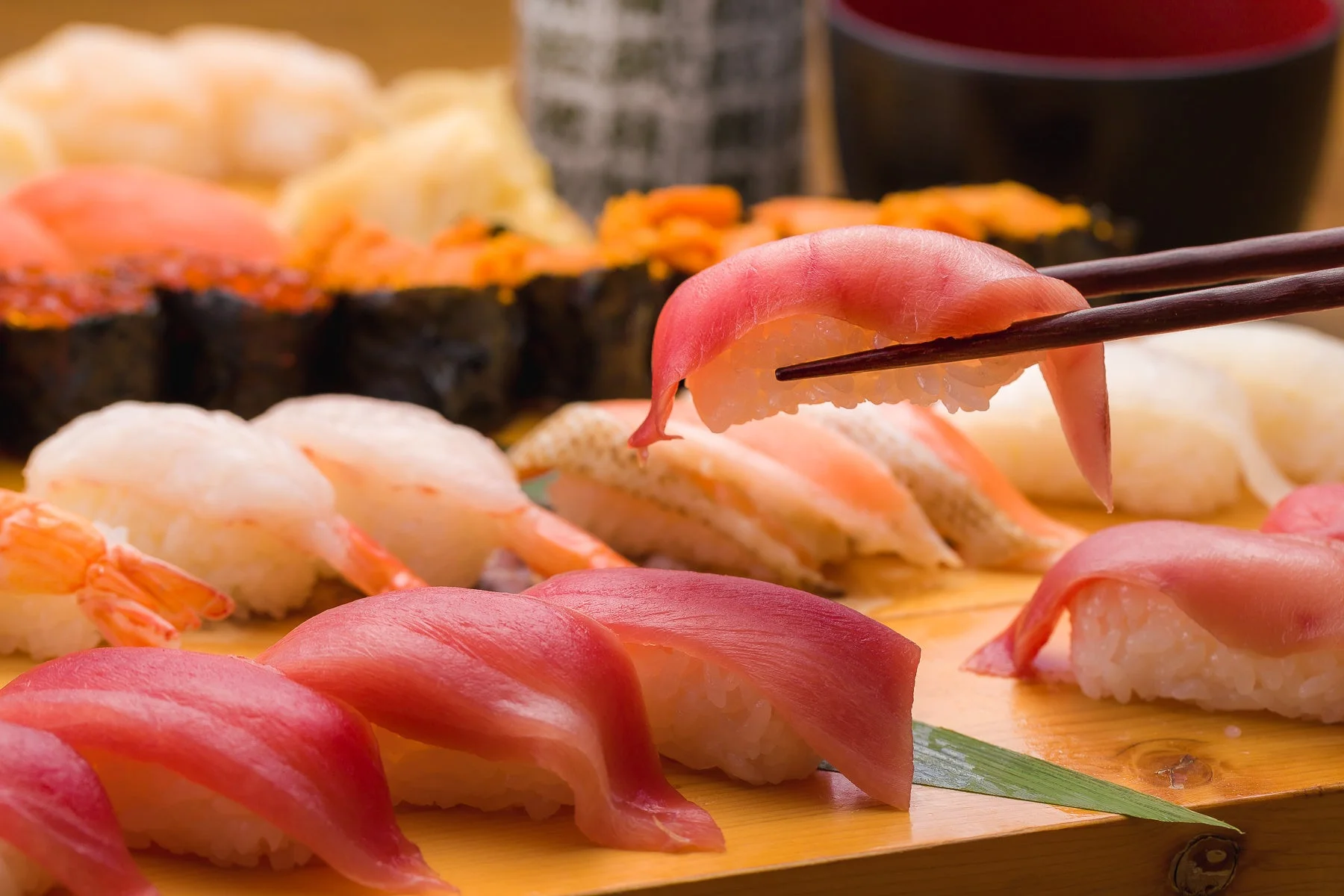 箸で持ち上げられたマグロの握り寿司