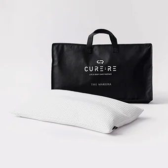 白い枕と、CURE:REのロゴが入った黒い収納バッグが写っています。シンプルで機能的なデザインの枕は、良質な睡眠やボディケアをサポートする製品のようです。