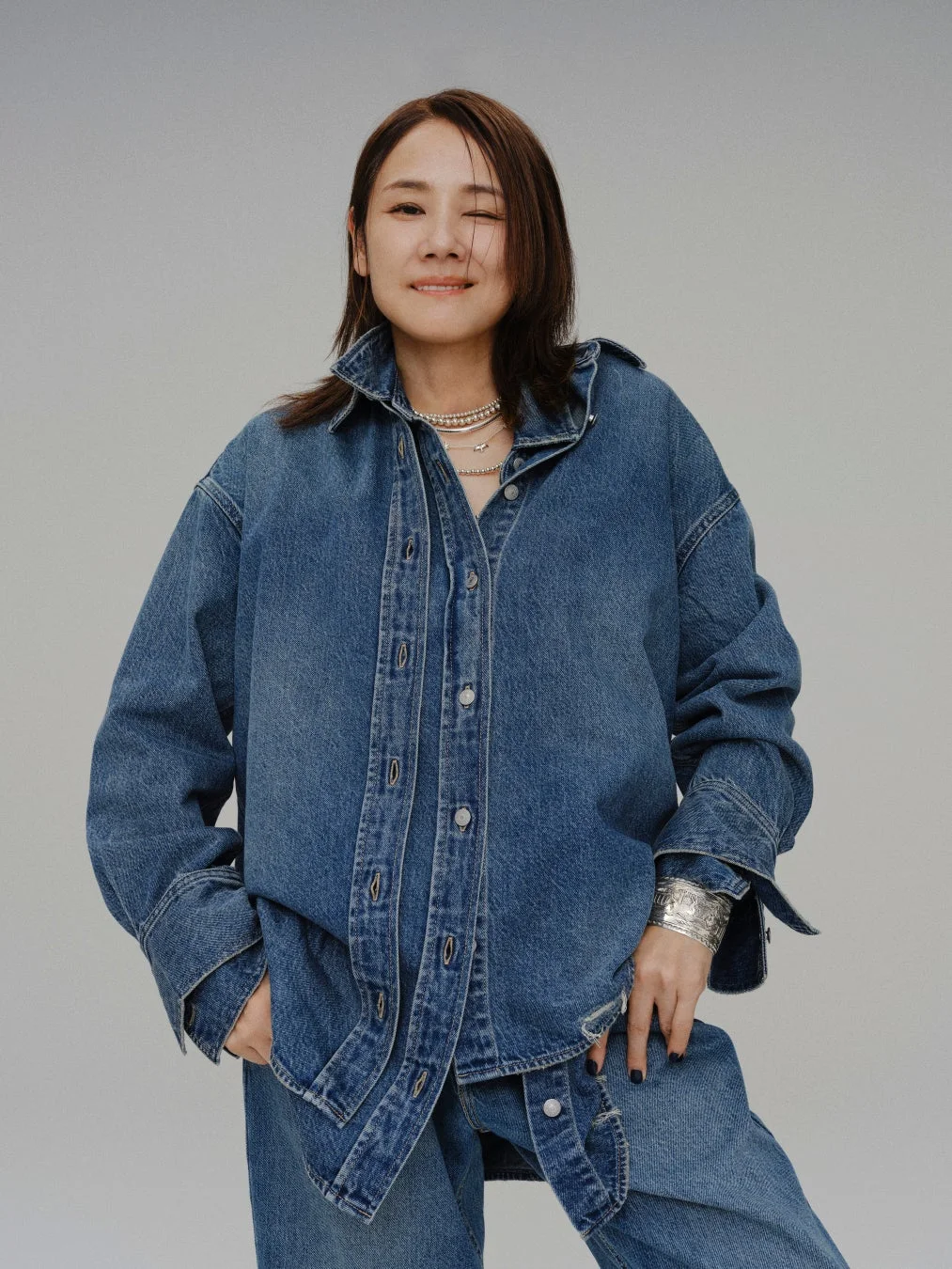 WOVEN DENIM SHIRTを着用しウィンクする女性