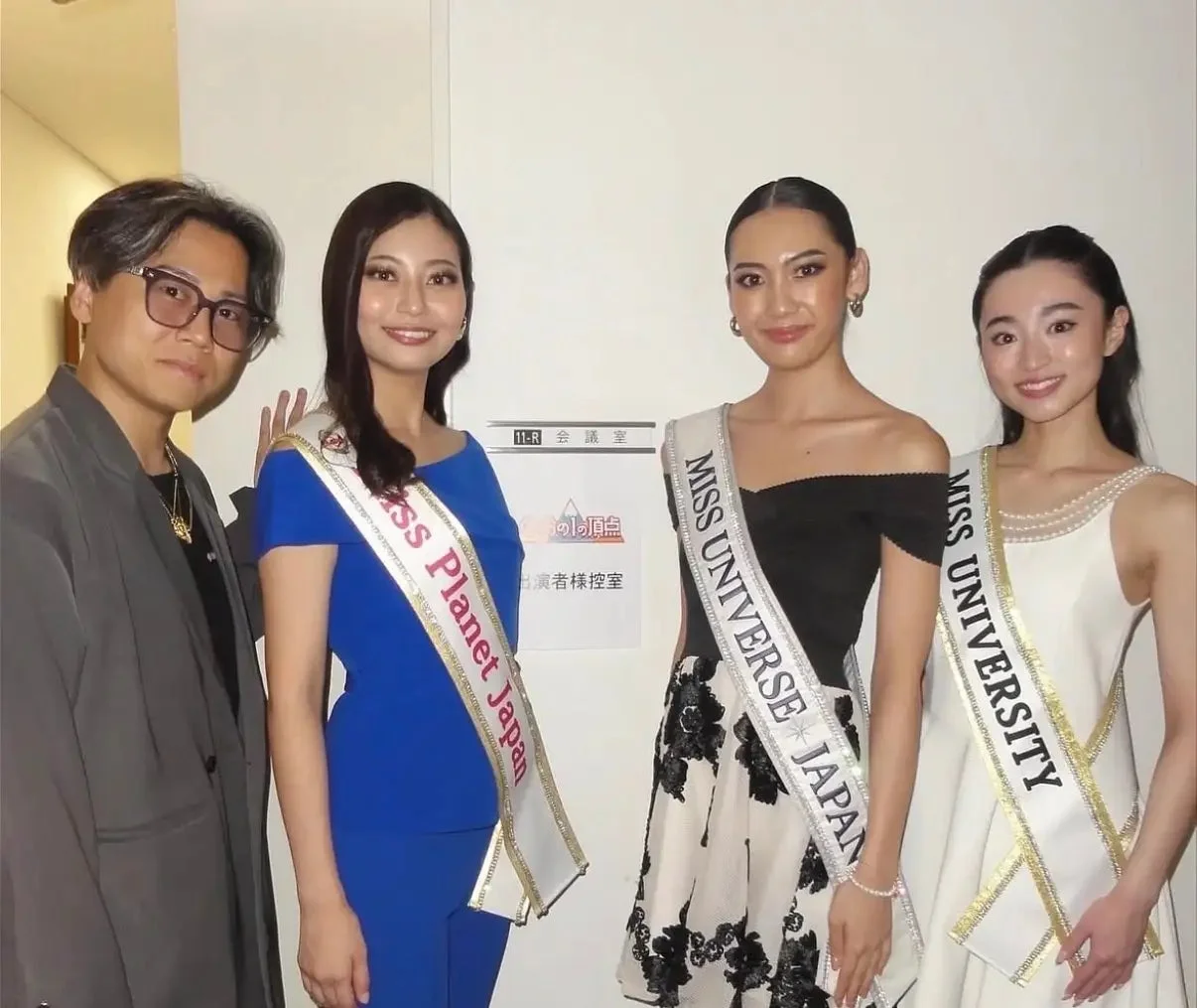 会議室での集合写真、サッシュをつけた女性たち