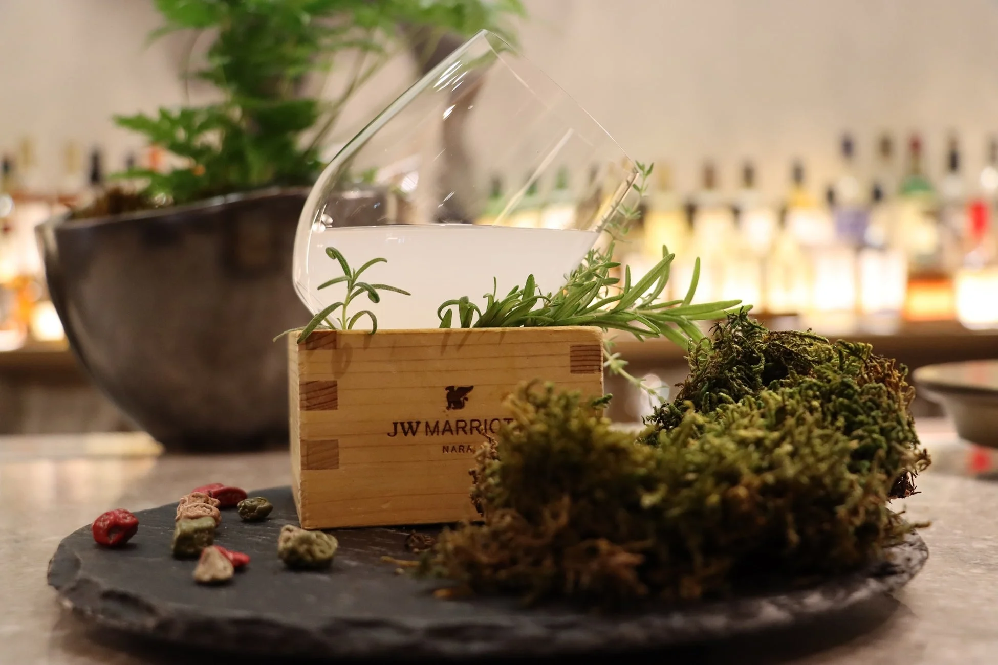 JWマリオット奈良のバーで提供される、ハーブと苔で飾られたユニークなカクテル。自然の要素を取り入れた洗練されたプレゼンテーションが特徴。