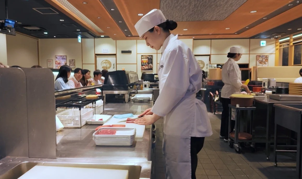女性料理人が魚を捌く様子