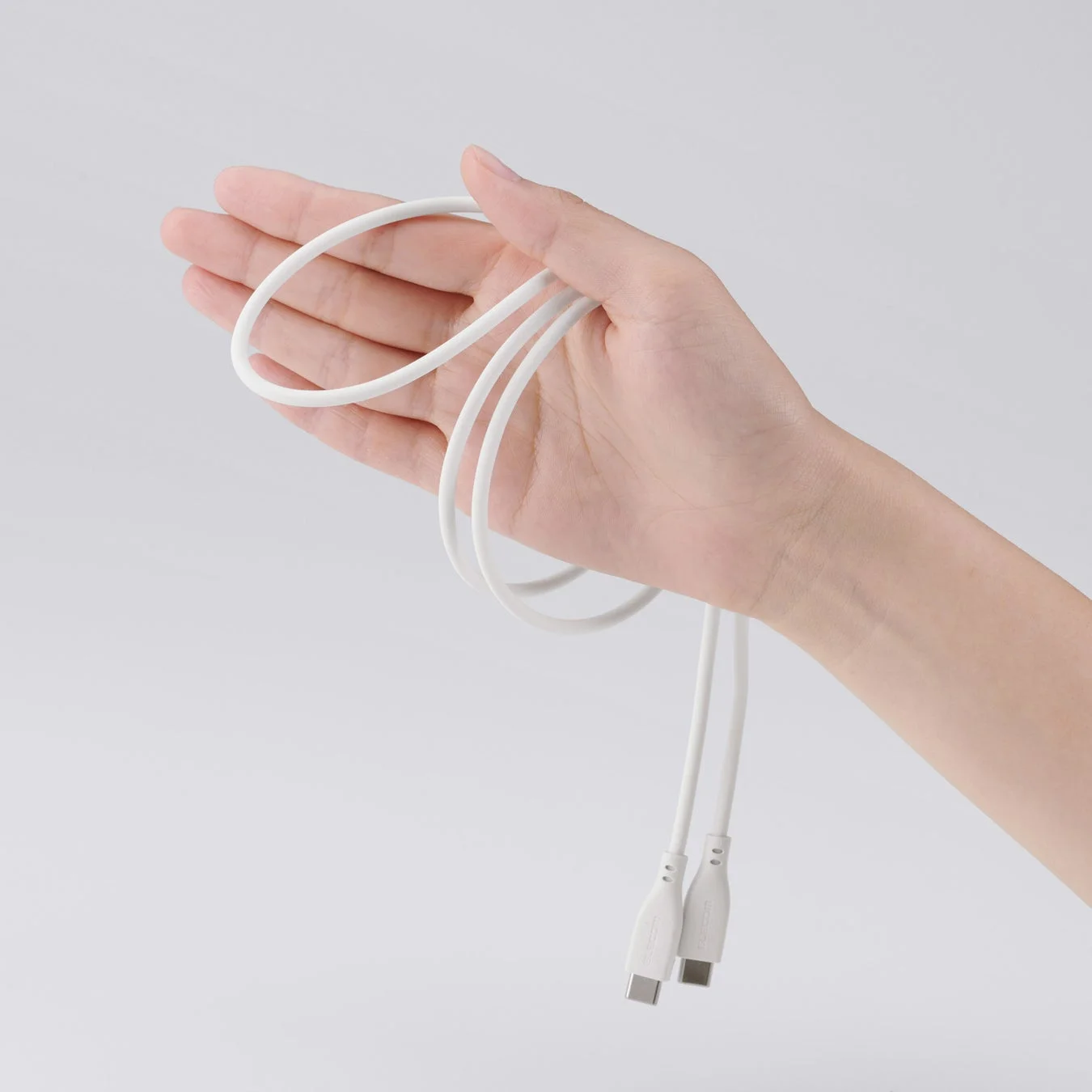 白いUSB-Cケーブルを持つ手
