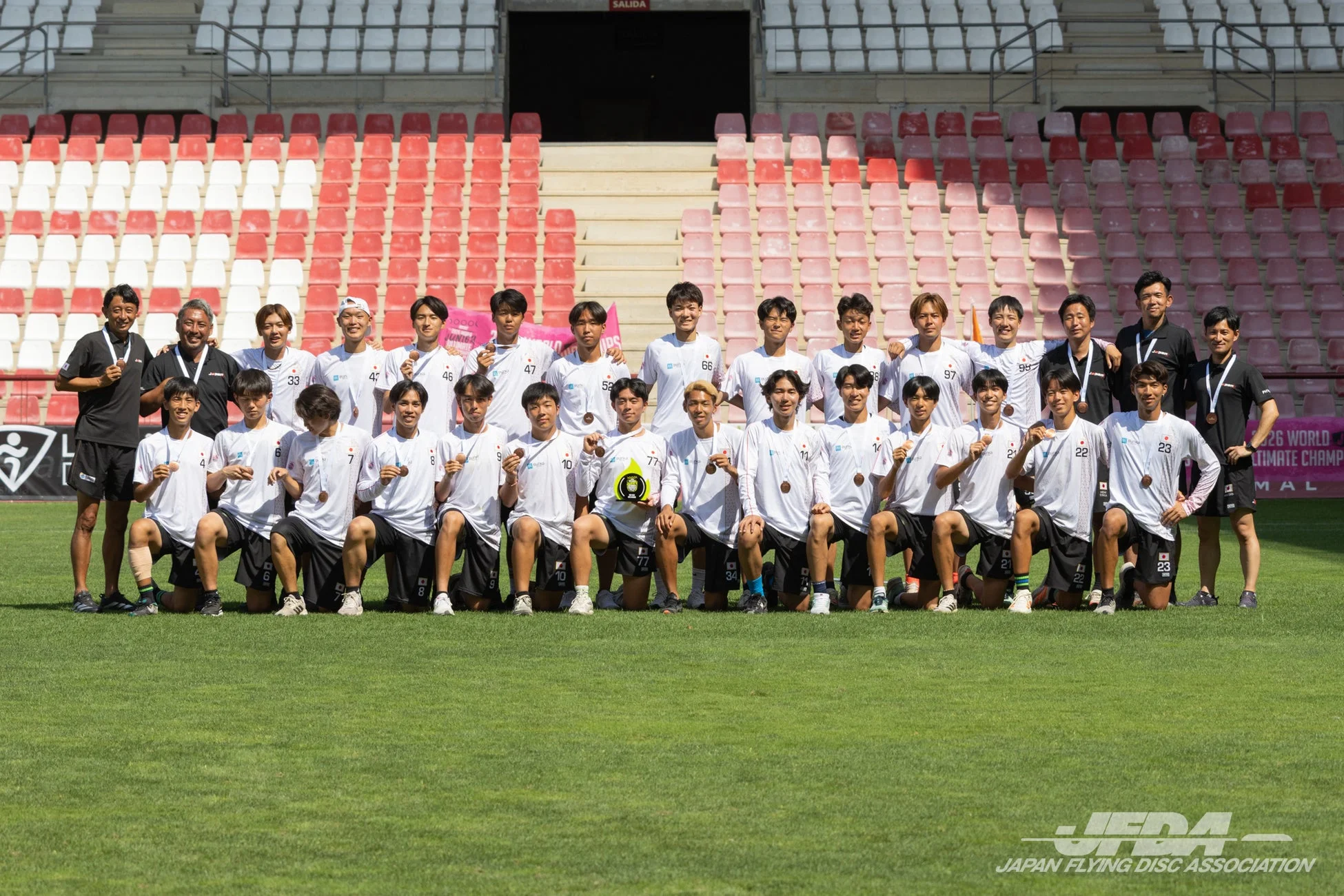 世界ジュニアアルティメット選手権大会での日本代表選手とコーチの集合写真