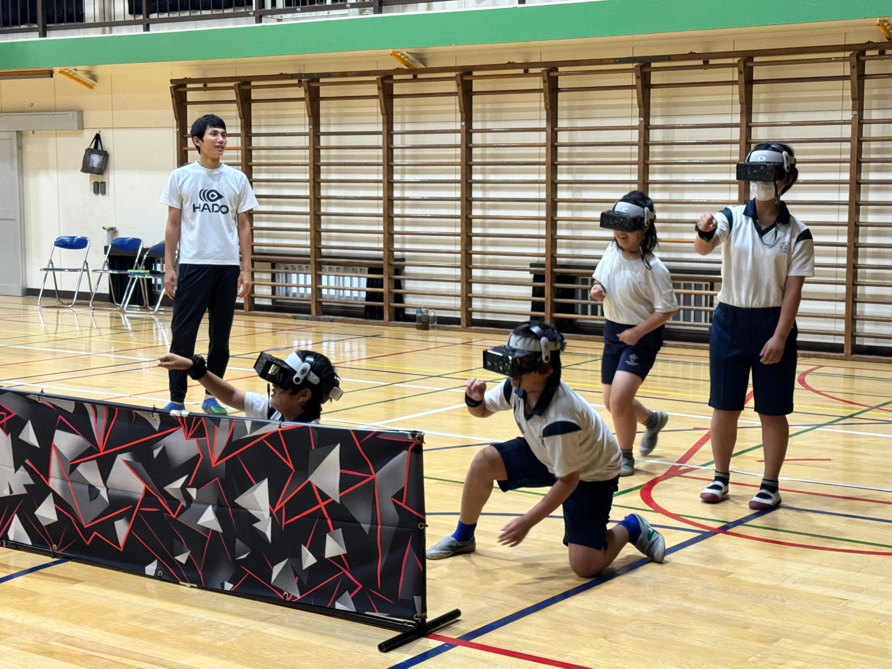 体育館でVRヘッドセットを装着した若者がHADOを楽しんでいる様子