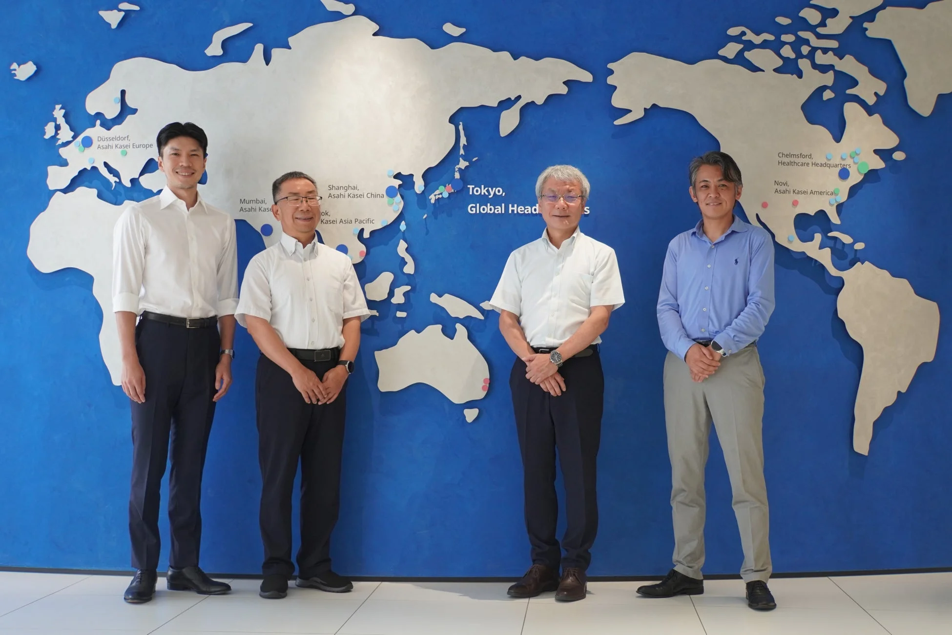 ビジネスマン4人と世界地図の画像