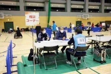 体育館のような広い会場で開かれているイベントの一角にある「相談コーナー」の様子です。