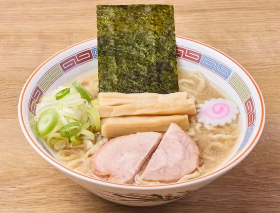 木目のテーブルに置かれたラーメンの丼ぶりの俯瞰写真