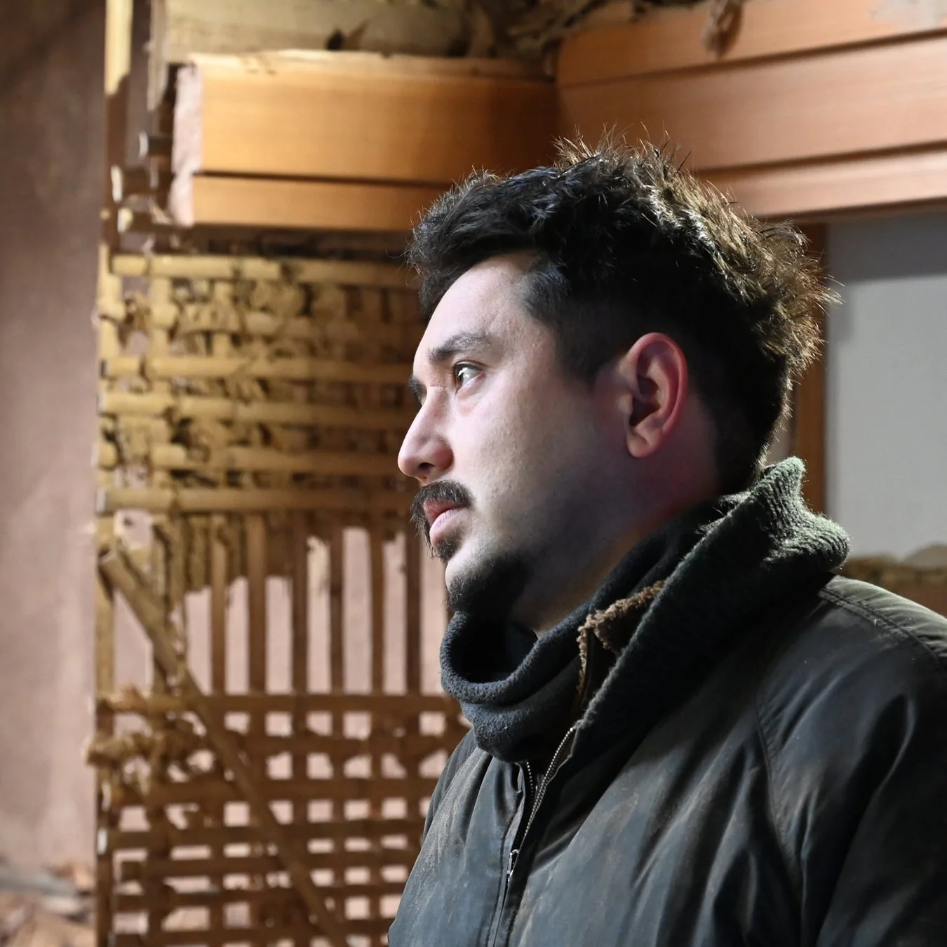 工事中または改装中の建物内で、横顔を見せる男性のポートレート