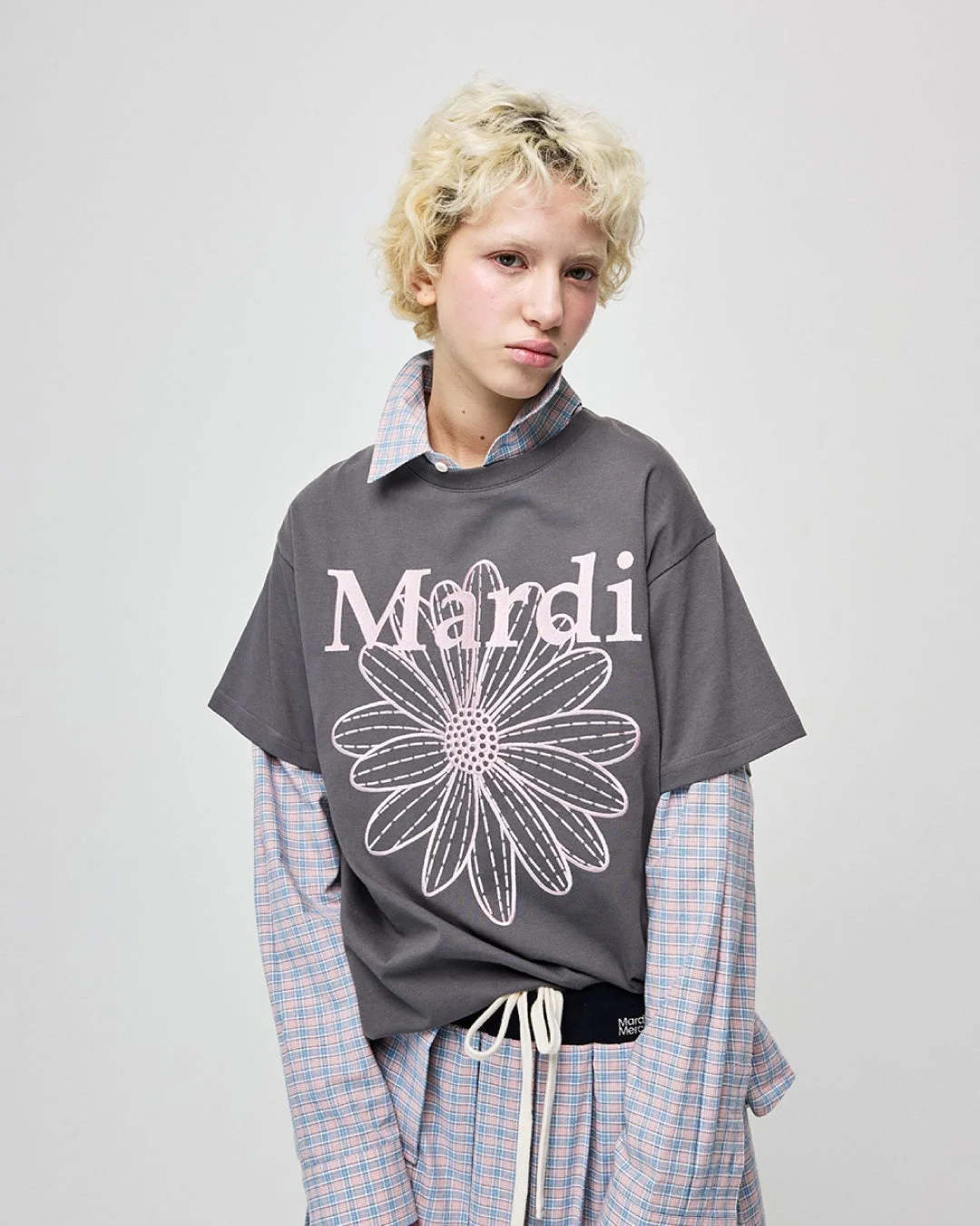 Mardi MercrediのTシャツとチェック柄シャツを重ね着した女性