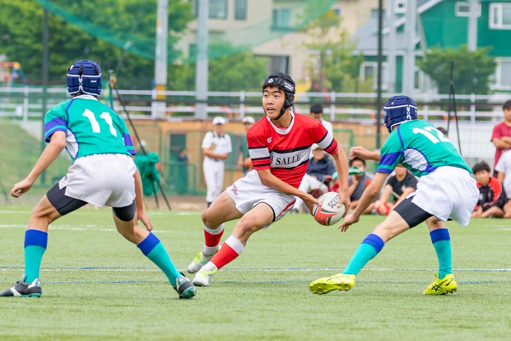 ラグビーの試合でボールを持って走る選手