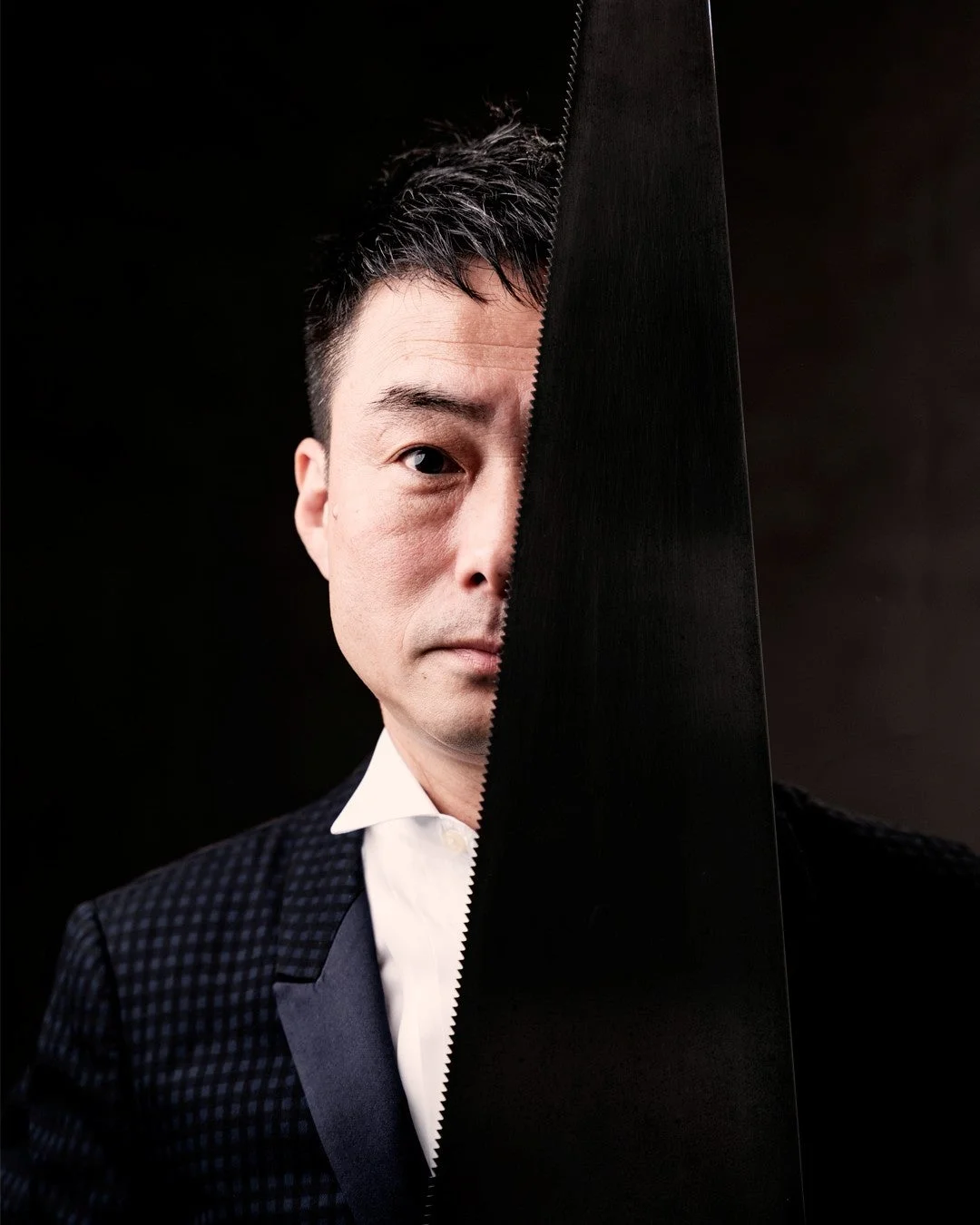 のこぎりを持つサキタハヂメさんのポートレート