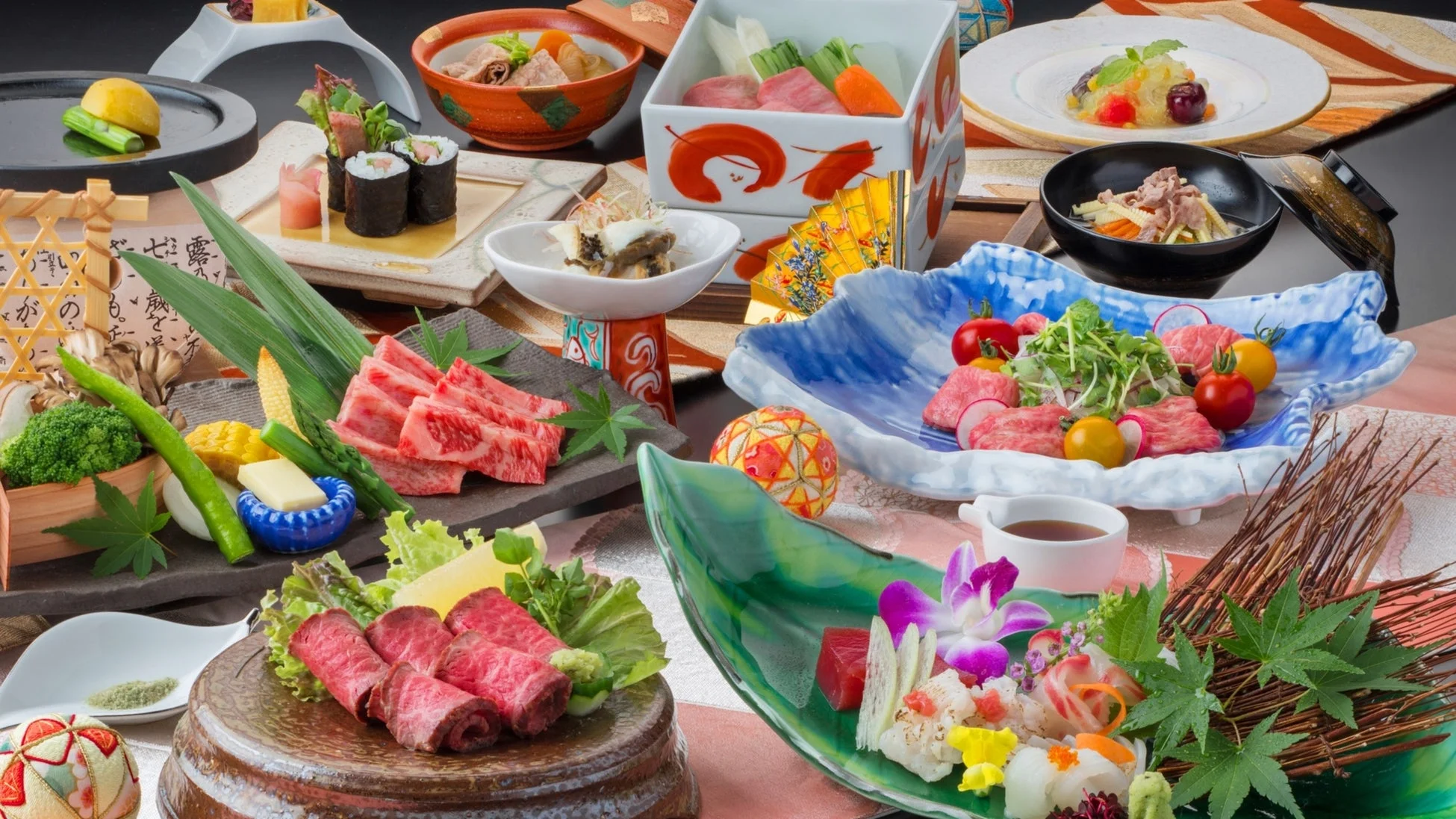 和牛の刺身や寿司、季節の野菜など、豪華で美しい盛り付けの日本料理が多数並んでいます。お祝いの席にふさわしい、手の込んだ懐石料理の光景です。