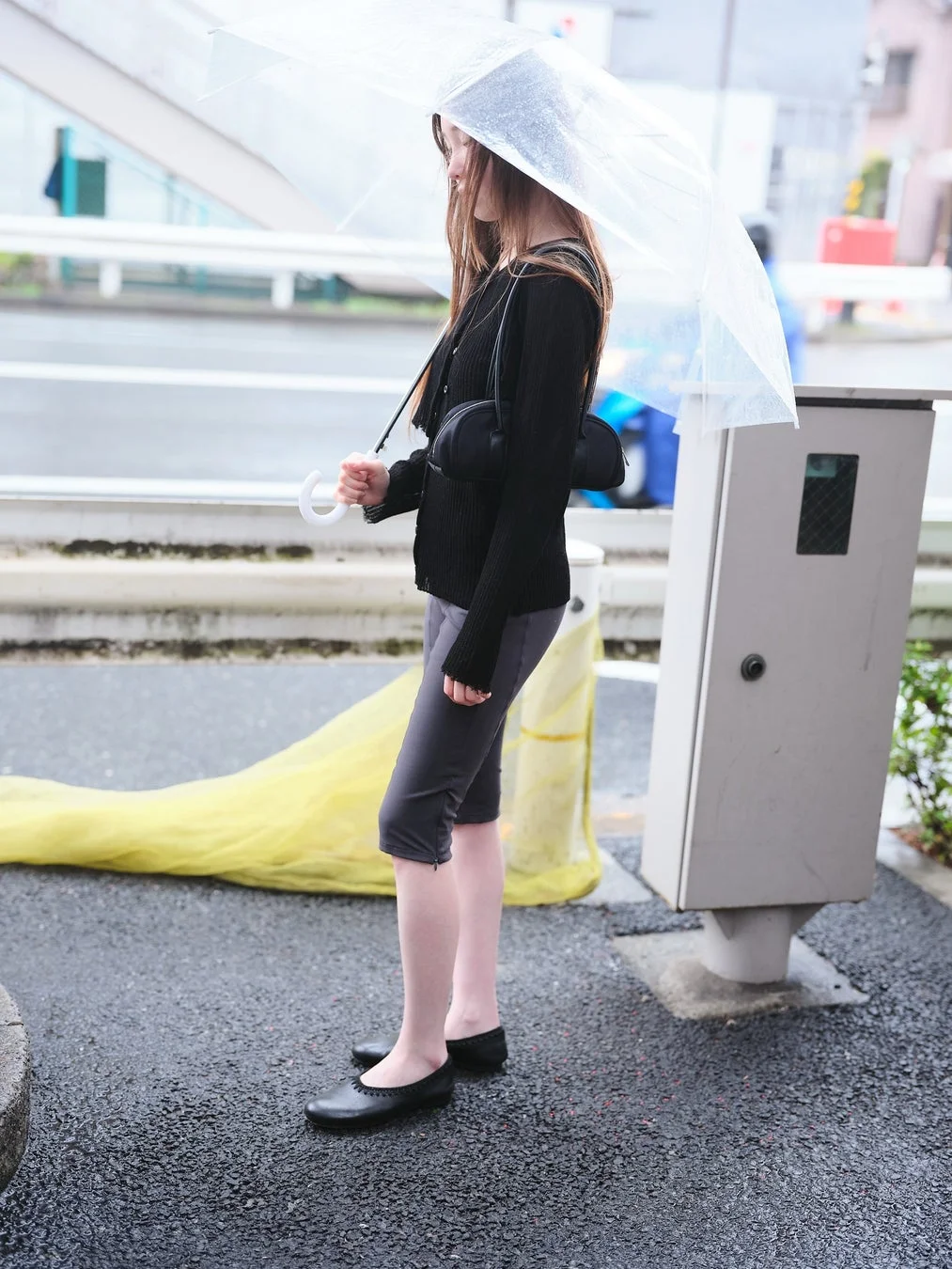 DIAGONALのアイテムを着用した女性が傘をさしている