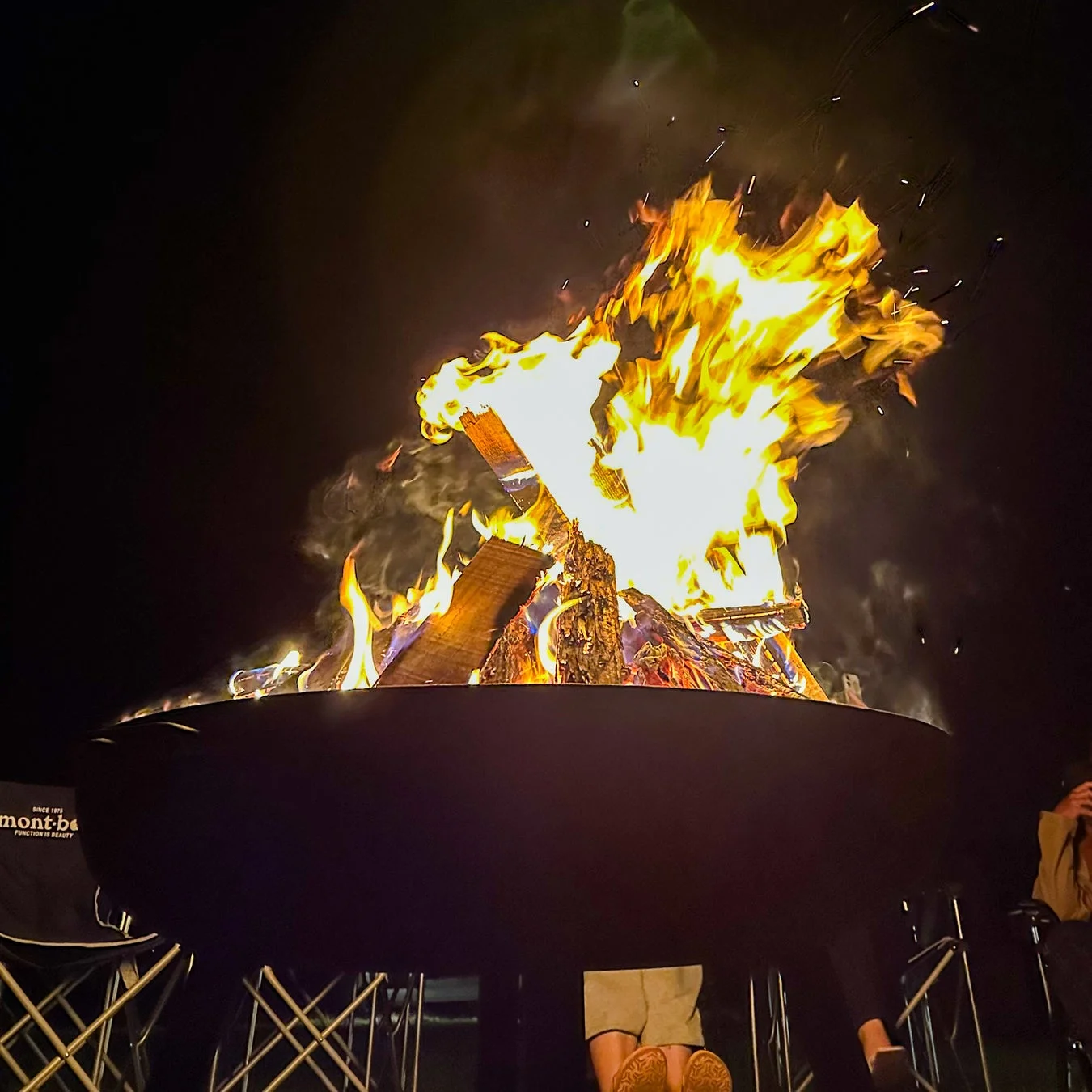 夜の屋外で大きな焚き火台が燃え盛る様子