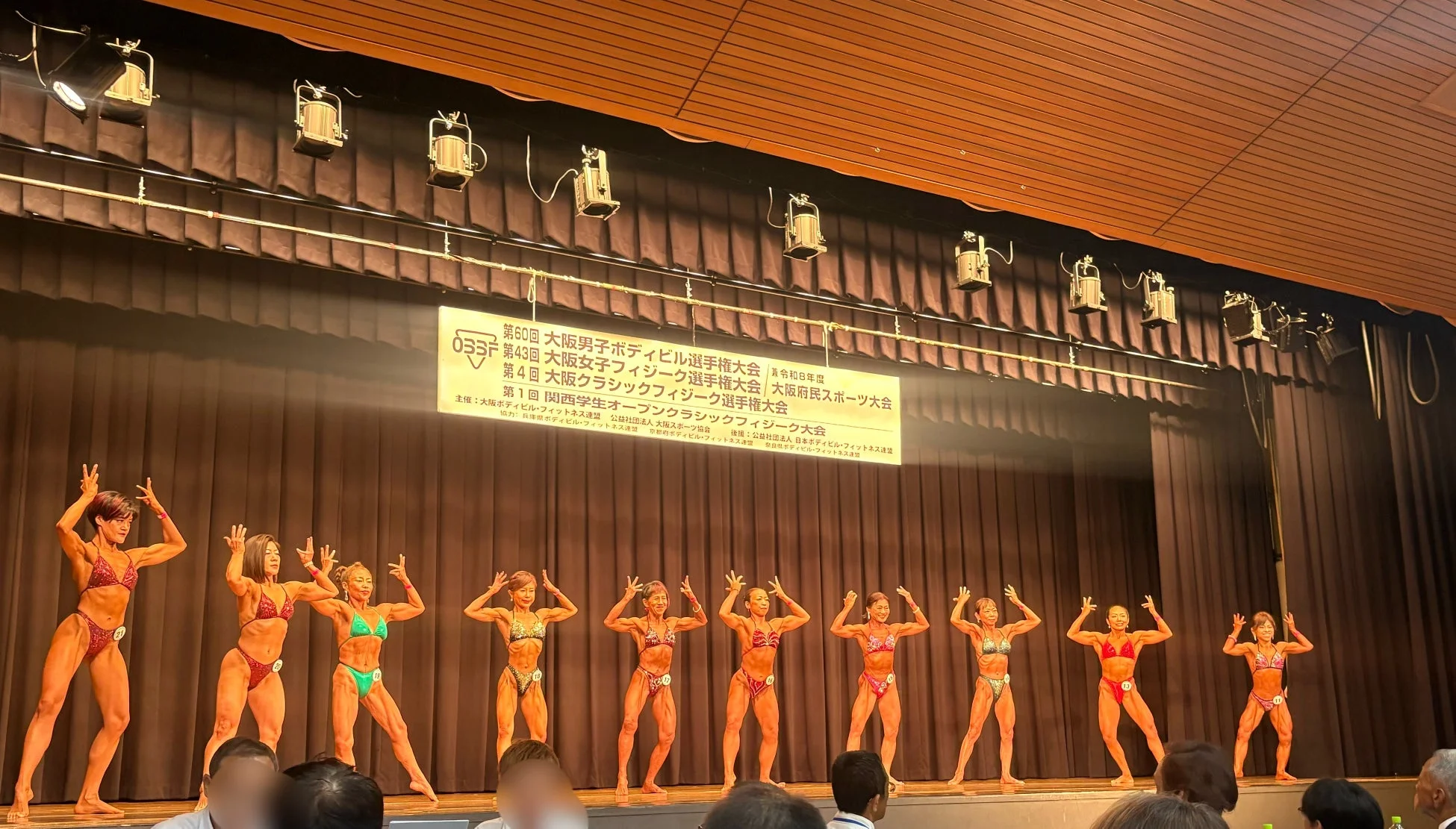 ボディビル大会のステージでポージングを披露する女性選手たち