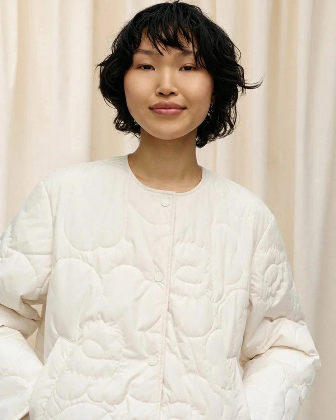 オフホワイトのキルティングジャケットを着た女性のポートレート