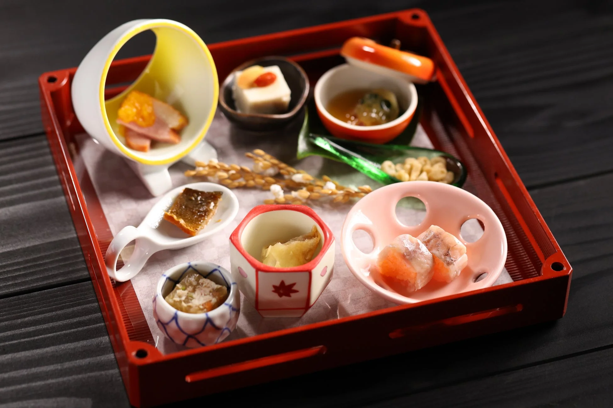 赤いお盆に美しく盛り付けられた和食の会席料理
