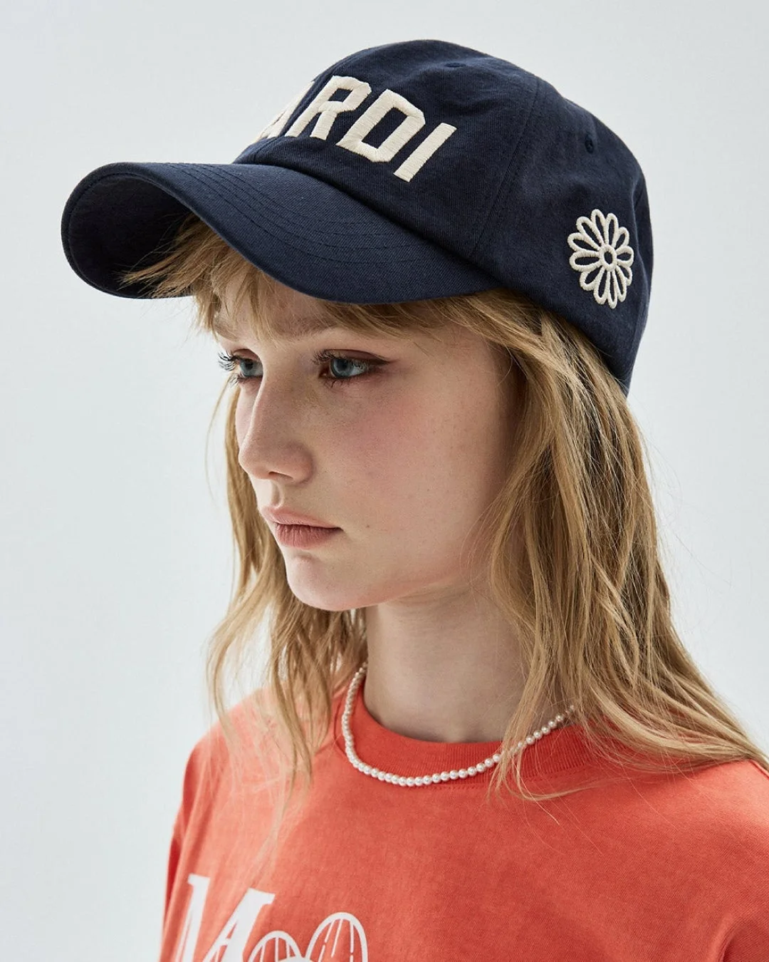 Mardi MercrediのキャップとTシャツを着用した女性