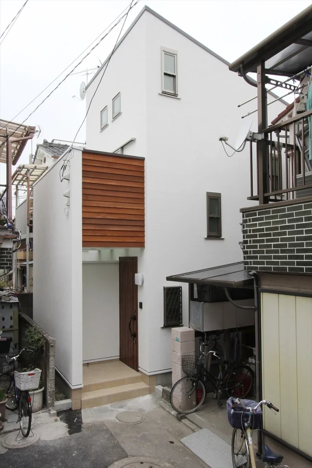 白い外壁と木目のアクセントが特徴的な現代的な住宅