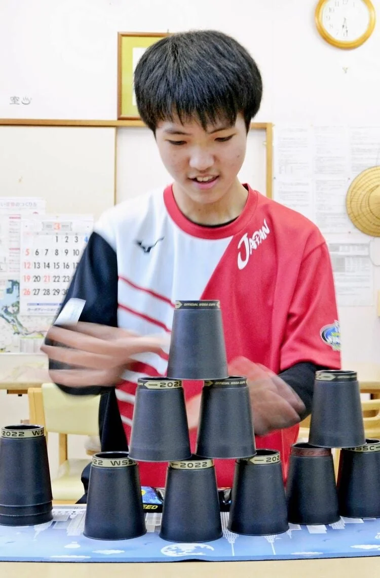 カップを積む少年