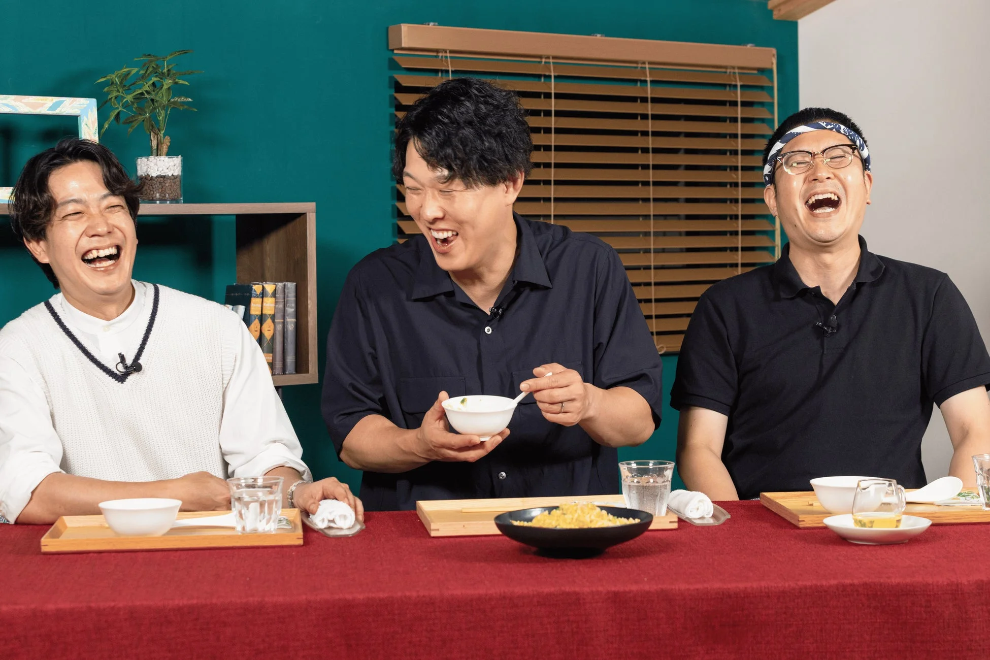 3人の男性が食事をしながら楽しそうに大笑いしている様子