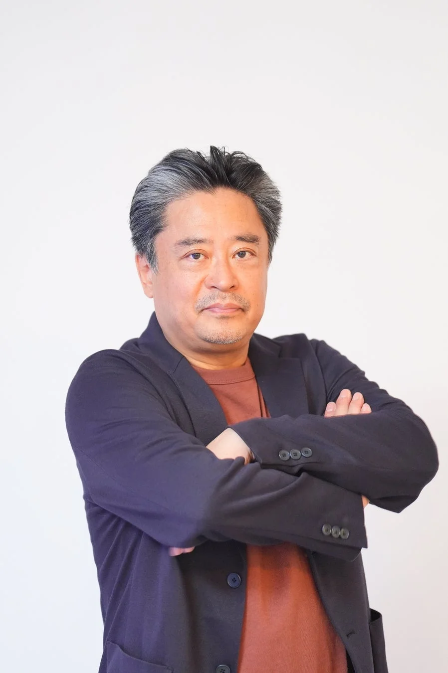 腕を組む松村武さんのポートレート