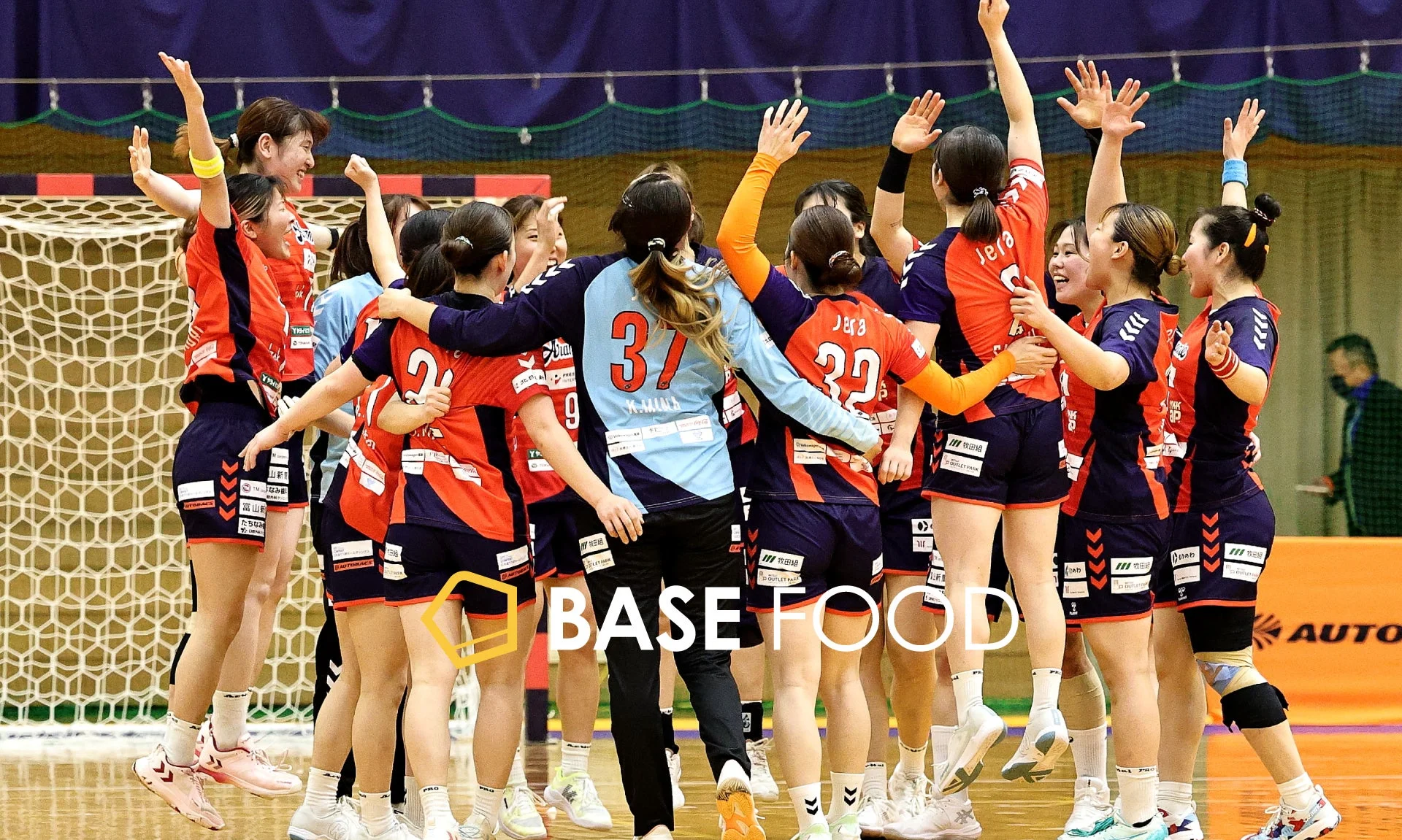 女子ハンドボールチームの選手たちが、試合中に円陣を組んで喜びを分かち合っている瞬間