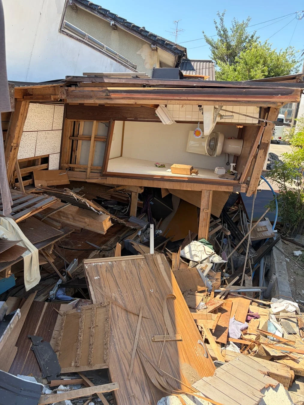 地震か自然災害により家屋が大きく損壊し、崩壊した様子