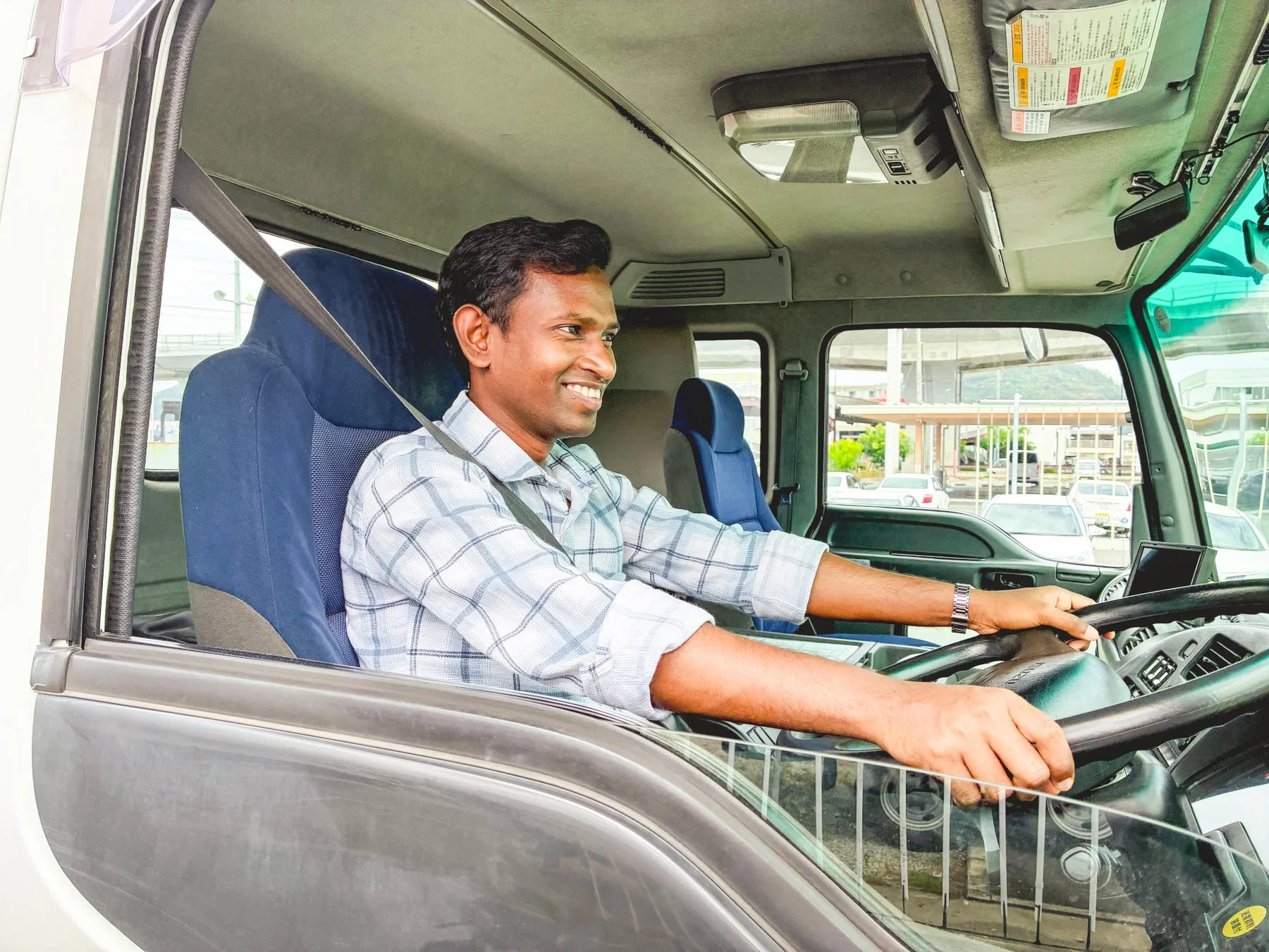 トラックの運転席で笑顔の男性