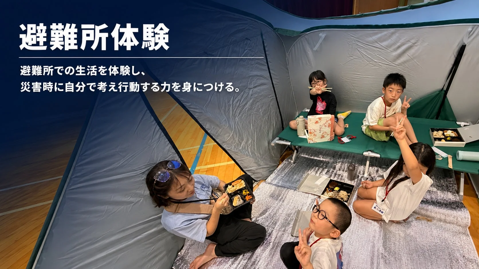 体育館のような屋内に設営されたテントの中で、子どもたちと大人が避難所での生活を体験している様子