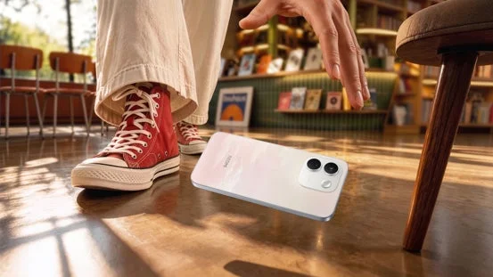 スニーカーを履いた人物がスマートフォンに手を伸ばしている様子