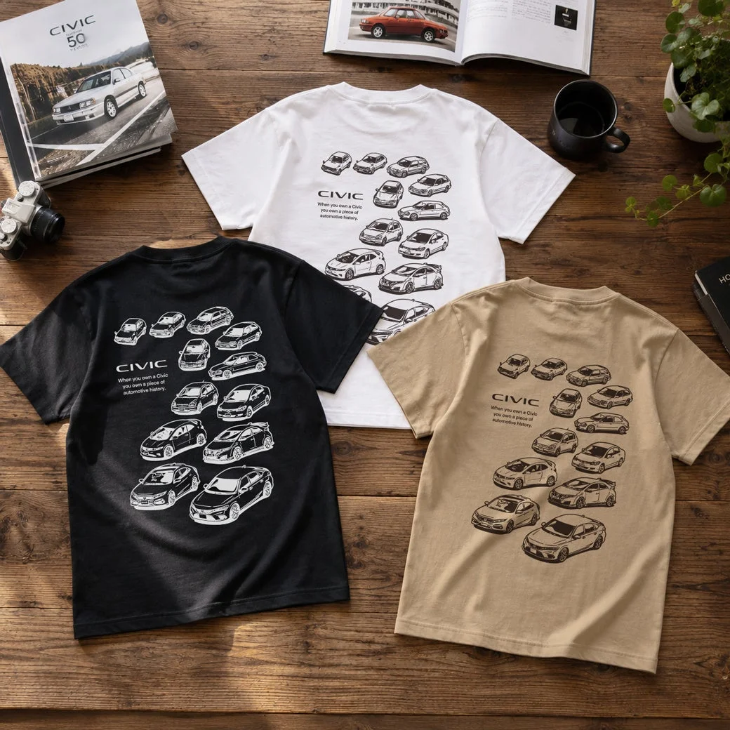 木製のテーブルの上に、ホンダ・シビックの歴代モデルがデザインされたTシャツが3枚と、「CIVIC 50 YEARS」と書かれた本