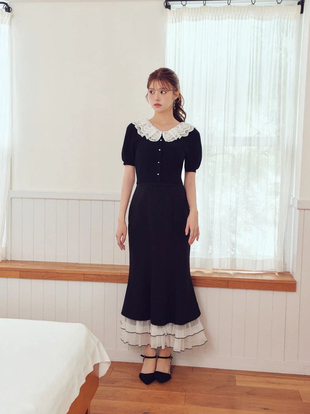 レース襟の黒ワンピースの女性
